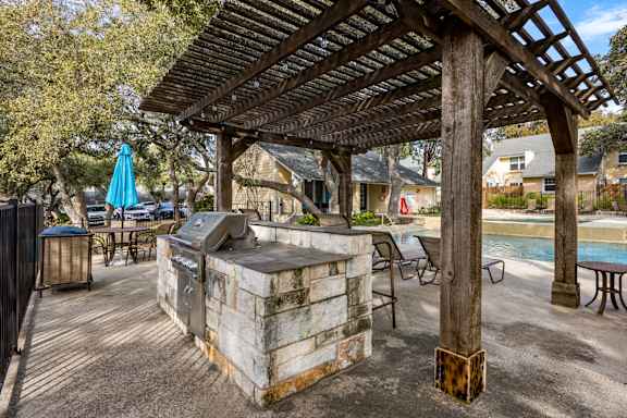 A wooden pergola is over a hot tub in a backyard. at The Arbors at Tallwood, Texas, 78759