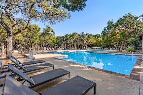 A pool surrounded by t at Bridge at Heritage Woods, Austin, TX