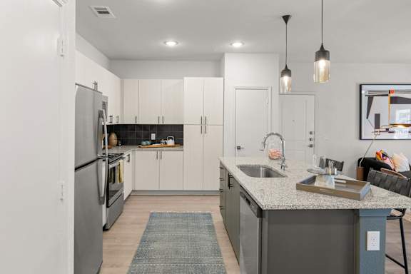 A modern kitchen with a large island and stainless steel appliances. at Bridge at Tech Crossing, Austin, TX, 78753
