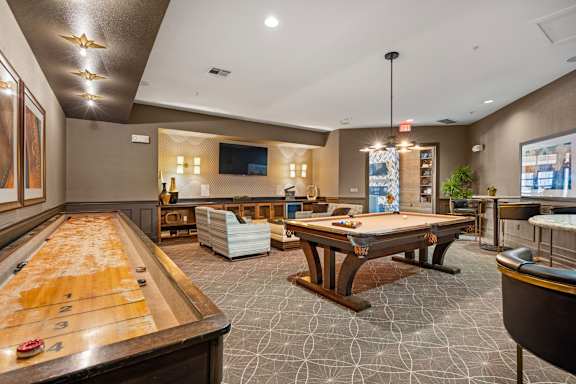 A billiards room with a pool table and a foosball table. at Bridge at Southpark Meadows, Austin, TX