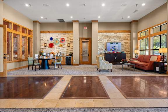 A room with a stone wall and a TV on it. at Bridge at Southpark Meadows, Austin, 78748