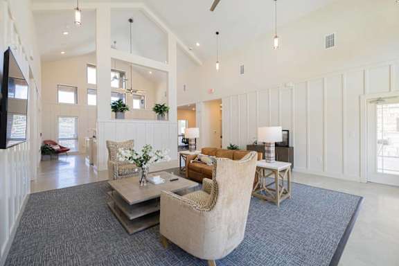 A spacious living room with a grey rug and a beige armchair.