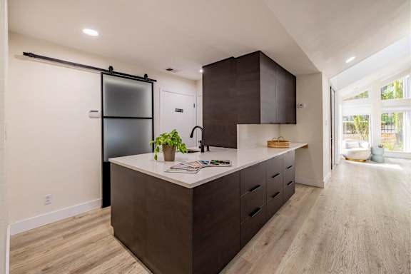 A kitchen with a white countertop and brown cabinets. at Montecito, Austin, TX, 78741