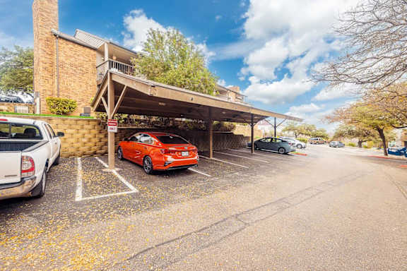 A parking lot with cars and a building in the background. at Montecito, Austin, TX, 78741