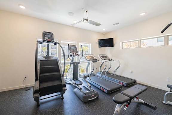 A spacious home gym with treadmills, elliptical machines, and a stair climber.