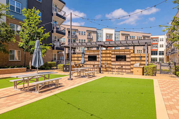 A small grassy area with a picnic table and a shade umbrella. at Bridge at Henley, Austin, Texas