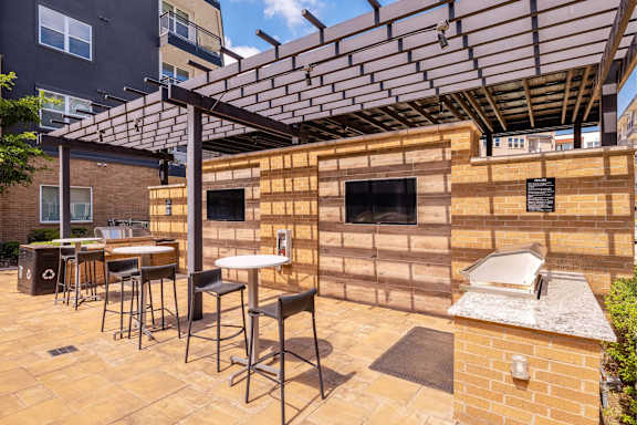 A patio with a table and chairs under a pergola. at Bridge at Henley, Austin