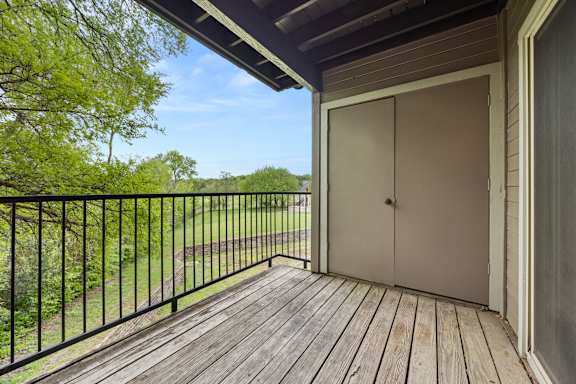 A balcony with a wooden floor and a white door. at Montecito, Austin, Texas