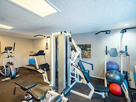 A gym with a variety of equipment including weights and machines.