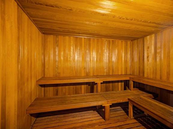 A wooden sauna with benches and a table.