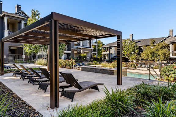 A patio with a pool and sun loungers. at Preserve at Rolling Oaks, Austin, TX, 78728