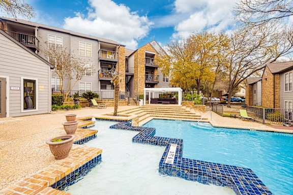 A swimming pool surrounded by apartment buildings. at Montecito, Texas, 78741