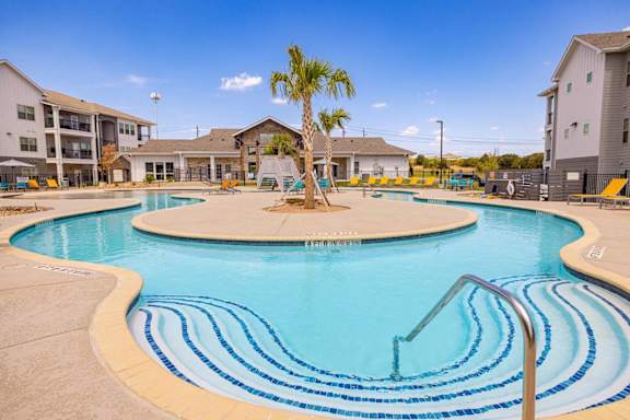 A palm tree stands in the middle of a round swimming pool.