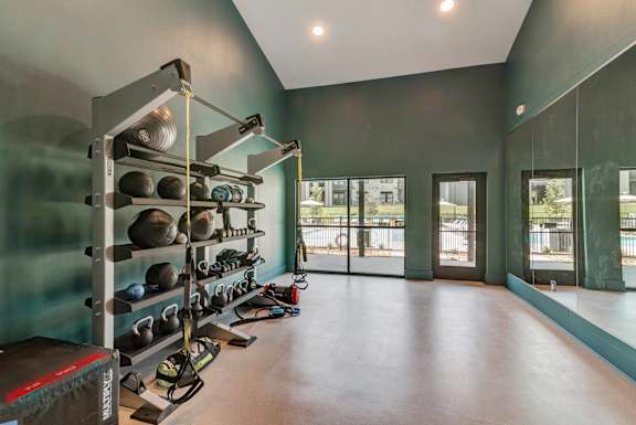 A gym with a row of kettlebells on the wall. at Bridge at Tech Crossing, Austin, TX