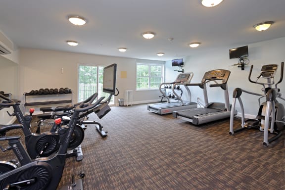 a room filled with cardio equipment and a flat screen tv