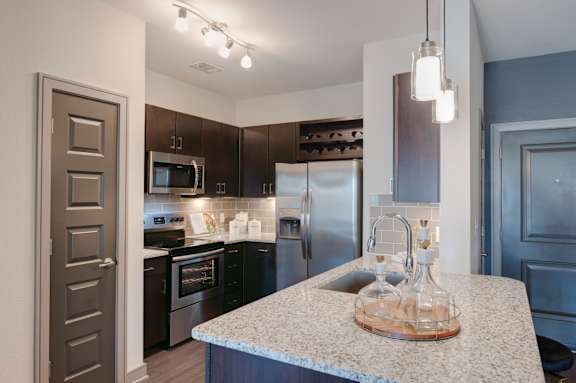 Kitchen with a granite countertop and stainless steel appliances at Caldwell, Houston, 77084