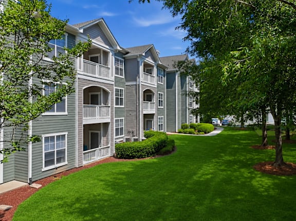 Three story apartment buildings with balconies and landscaping at Alden Place at South Square Apartments, Durham, NC