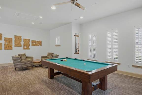 Billiards lounge with pool table and armchairs at Alden Place at South Square Apartments, Durham, NC 27707