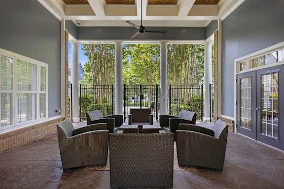 Covered patio with ceiling fan and wicker seating at Alden Place at South Square Apartments, Durham, NC 27707
