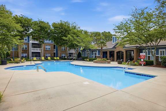 Community swimming pool with clubhouse and mature trees at Alden Place at South Square Apartments, Durham, 27707
