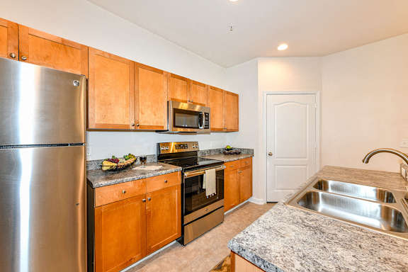 Modern kitchen with stainless steel appliances and granite countertops at Alden Place at South Square Apartments, Durham, North Carolina