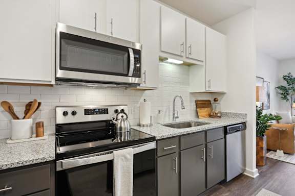 A modern kitchen with a black stove top oven and a microwave above it at Arcadia Cartersville Apartments, Cartersville, Georgia
