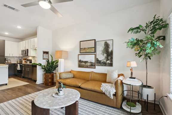 A living room with a yellow couch and a white coffee table at Arcadia Cartersville Apartments, Cartersville