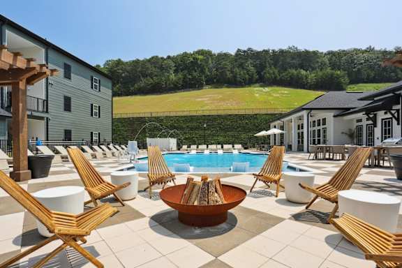 A large outdoor patio with a pool and chairs at Arcadia Cartersville Apartments, Georgia, 30121
