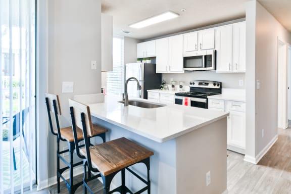 a kitchen with a large island with three stools