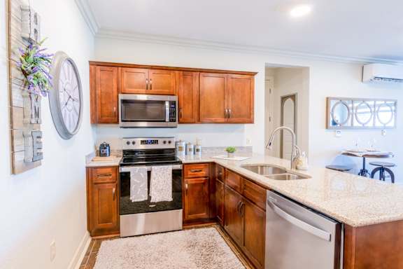 A kitchen with wooden cabinets and a stove top oven.at Carson Street Towers, Kansas, 66223