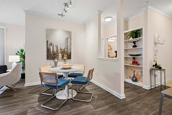 Dining area with round table and blue upholstered chairs at Alden Place at South Square Apartments, Durham, North Carolina