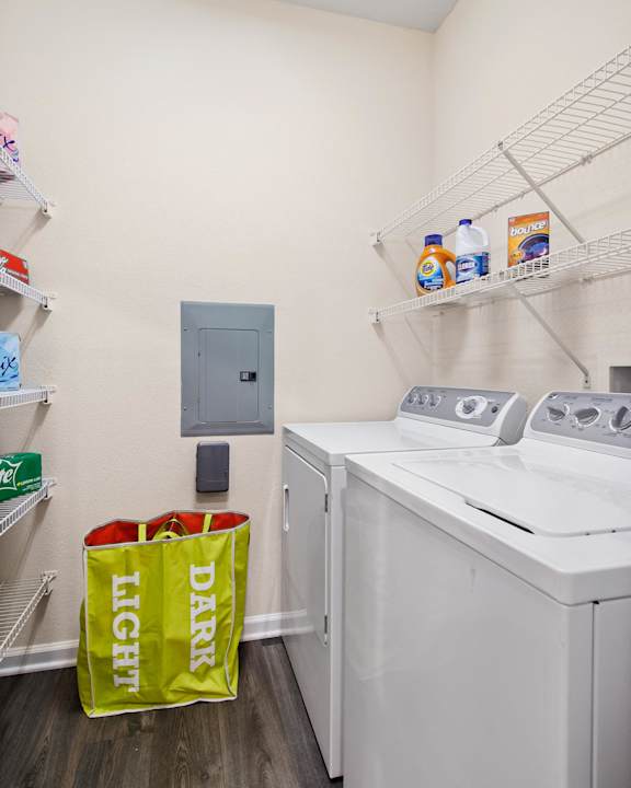 Laundry room with storage shelves and sorting hamper at Alden Place at South Square Apartments, Durham, 27707