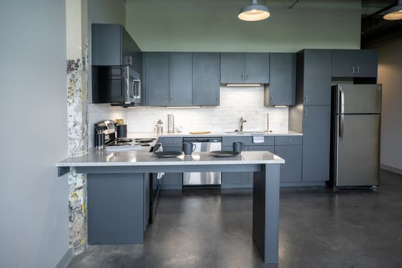 a kitchen with gray cabinets and stainless steel appliances