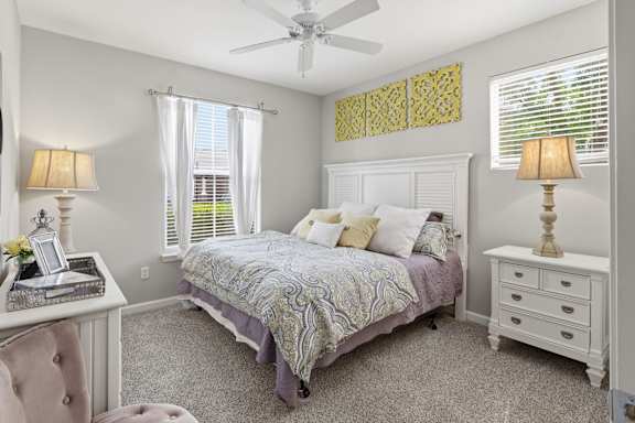 A bedroom with a bed, nightstand, and window.