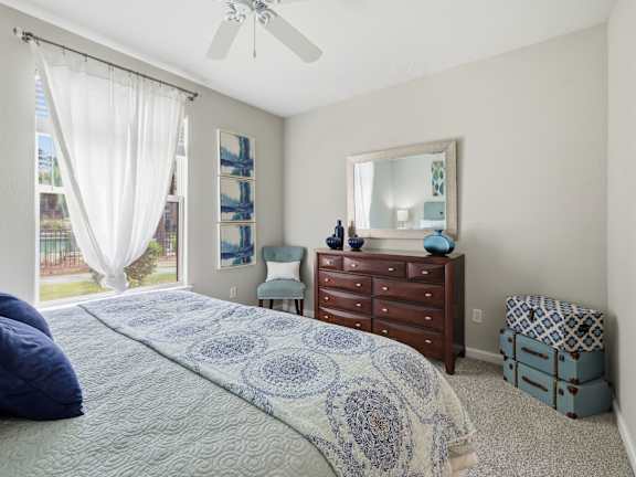 A bedroom with a bed, dresser, and mirror.