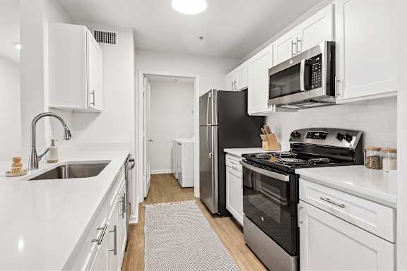 A kitchen with white cabinets and appliances.