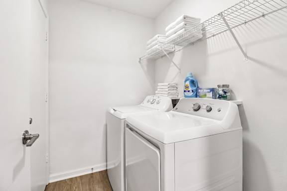 A white washing machine and dryer in a small laundry room.