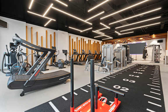 a gym with cardio equipment and weights on the floor at Deca Apartments, Greenville, 29601