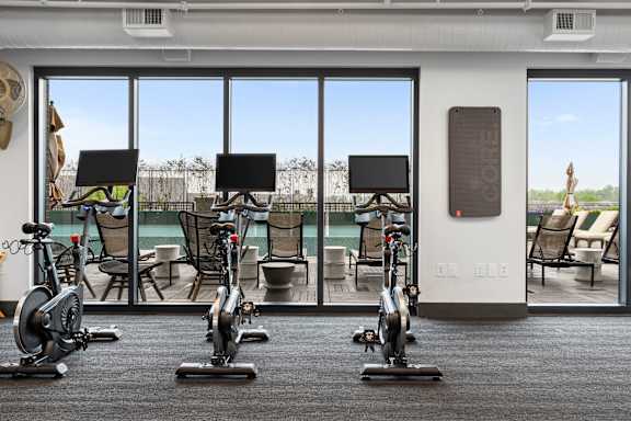 a gym with exercise machines and a view of a pool at Deca Apartments, South Carolina