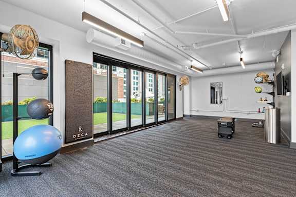 a workout room with a yoga ball and other exercise equipment in front of a window at Deca Apartments, Greenville, South Carolina