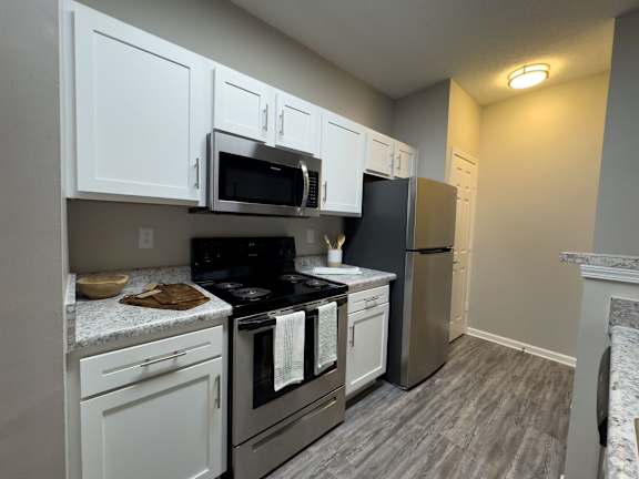 A kitchen with white cabinets and a black stove top at Enclave at Wolfchase Apartments, Memphis, TN 38016