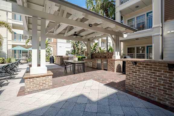 A patio with a table and chairs under a roof at Park Place Oviedo Apartments, Oviedo, FL