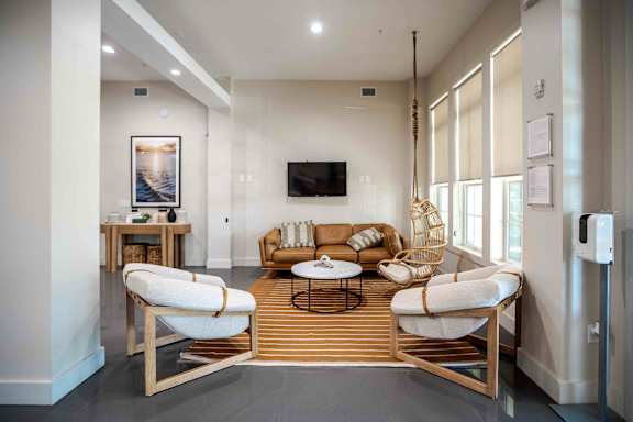 A modern living room with a white sofa and a wooden coffee table at Park Place Oviedo Apartments, Florida