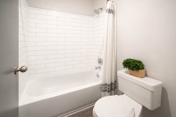 White bathroom with a white toilet and a bath tub at 1900 Rosemont, Roswell, Georgia