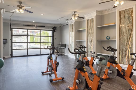 an indoor cardio room with exercise bikes and a window  at Arlo Luxury homes Apartments, Little Rock, AR,72210