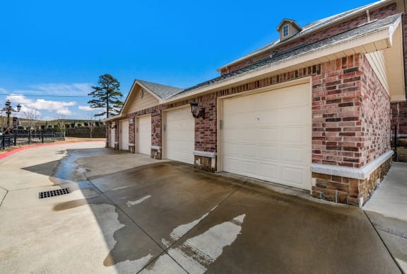 a white garage door on a brick building with a driveway  at Arlo Luxury homes Apartments, Little Rock