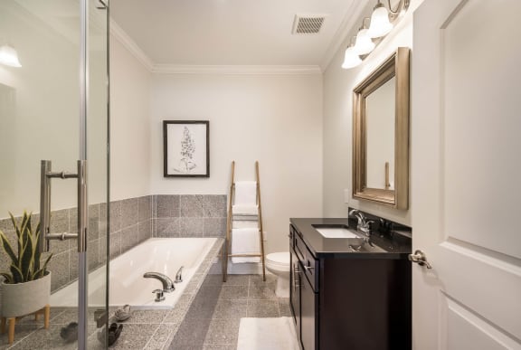 a bathroom with a tub and a sink and a mirror &#xA0;at Arlo Luxury homes Apartments, Little Rock, 72210