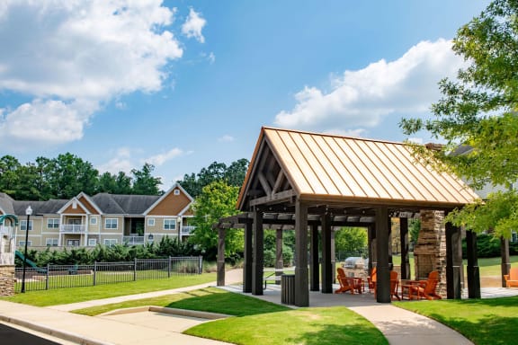 a pavilion with a lawn and trees in the background at Ashby at Ross Bridge, Alabama
