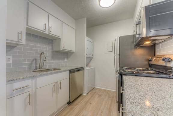 a kitchen with white cabinets and a stove and a refrigerator&#xA0;at Brightwaters Apartments, Little Rock, Arkansas