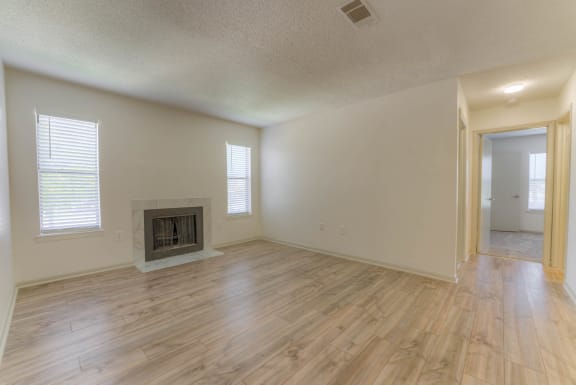 Living room with a fireplace and wooden floors&#xA0;at Brightwaters Apartments, Arkansas